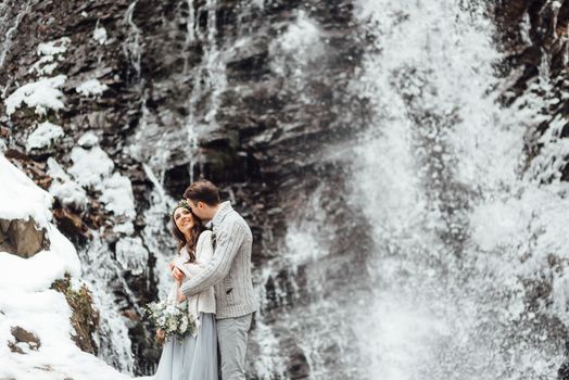 bride and groom on the background of a mountain waterfall