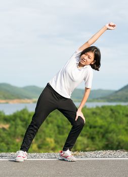 Fitness and lifestyle concept - Young asian woman short hair doing exercising outdoor and warm up preparing for jogging