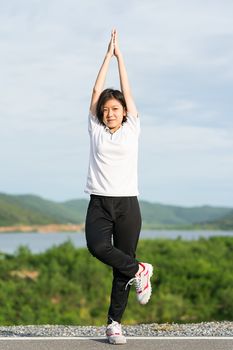 Fitness and lifestyle concept - Young asian woman short hair doing exercising outdoor and warm up preparing for jogging