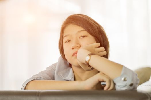 Close up beautiful young asian woman short hair relaxation by side the window in living room at home