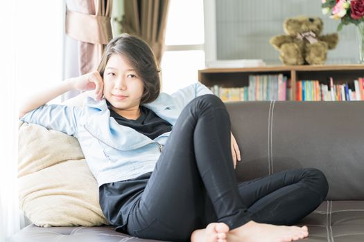 Close up beautiful young asian woman short hair relaxation by side the window in living room at home