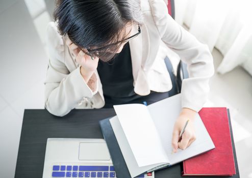 Woman short hair in smart casual wear working on laptop while sitting near window in home office