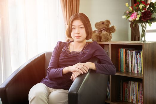 Close up beautiful young asian woman short hair relaxation by side the window in living room at home