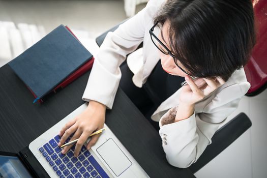 Young asian woman short hair in smart casual wear working on laptop in home office