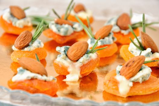 Cocktail snack from dried apricots with gorgonzola and almonds