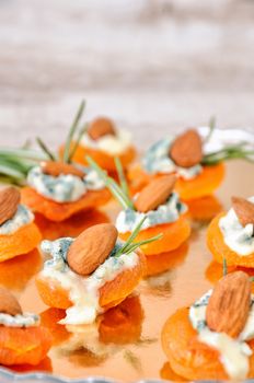 Cocktail snack from dried apricots with gorgonzola and almonds