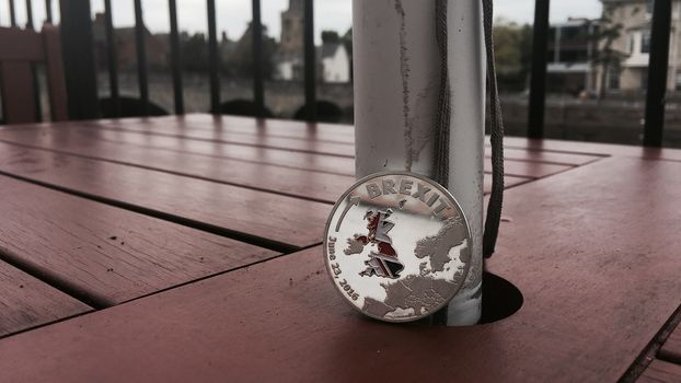 Europe leaving. Article 50. Silver brexit coin with british map. Outdoor concept.