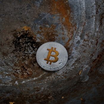 Crypto currency physical metal silver bitcoin coin on dirty scene.