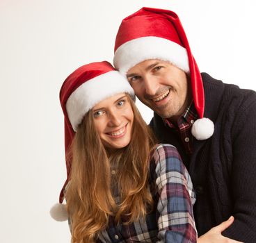 Happy beautiful couple in Santa hats, winter holidays Christmas New Year concept, isolated on white background