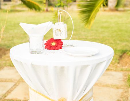 Beautiful elegant white table set for wedding or event party on table red flower, outdoor.