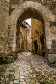 Paved street and arch in Carennac in Vallee-de-la-Dordogne in France