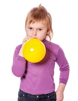 Little girl inflating yellow balloon isolated over white