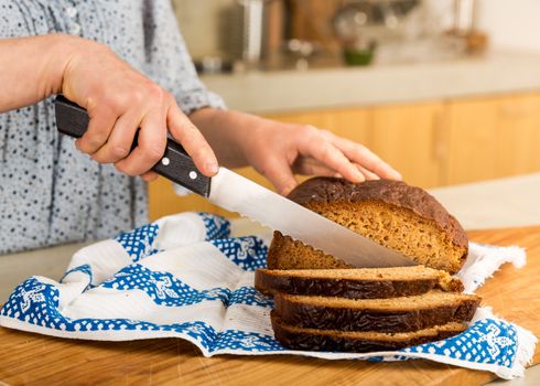 Woman cutting slices of gluten-free bread 