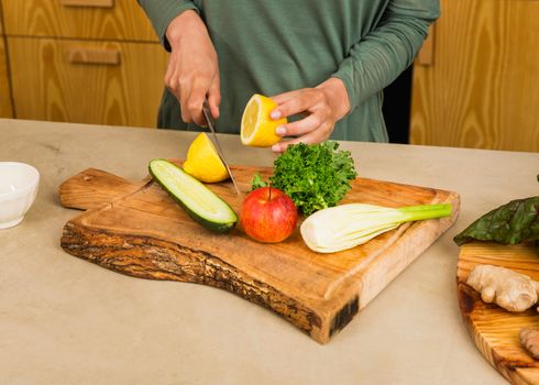 Several vegetables on top of a wooden board. Ingredients for detox juice.
