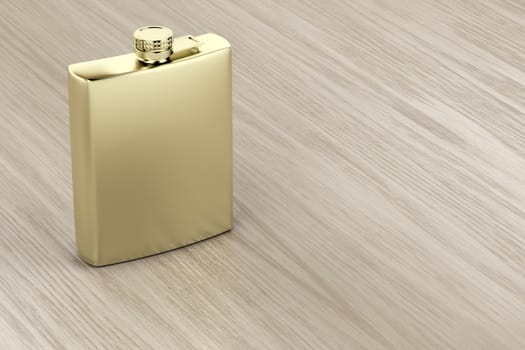Golden hip flask on wooden table