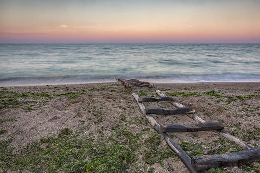 Stairway to sea. Dry wooden boat dock in the sand 