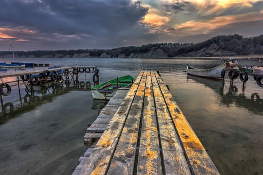 exciting landscape of wooden pier and boats at sunset