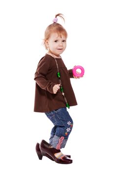 Funny little girl wearing mother's shoes isolated on white