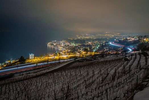 Montreux at night with view on Geneva lake in the background and vineyards under the snow