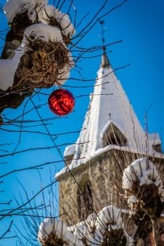 Christmas ball and clock tower in the snow in Switzerland