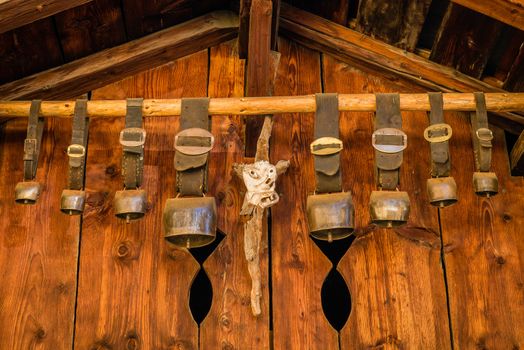 Cow bells hanging from a wooden chalet in Switzerland