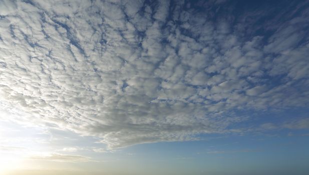 Pretty high cloud streaming above in the sky with light coming from the left of the image.