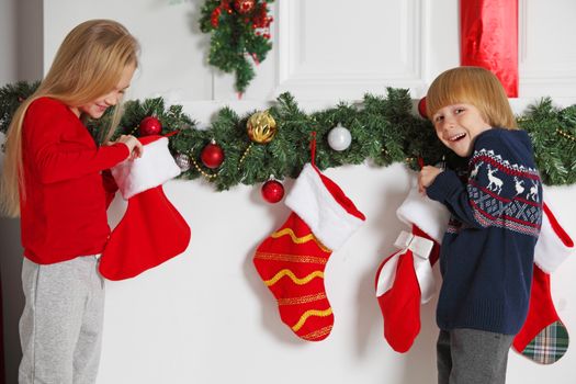 Adorable little children open their stocking gifts on Christmas morning