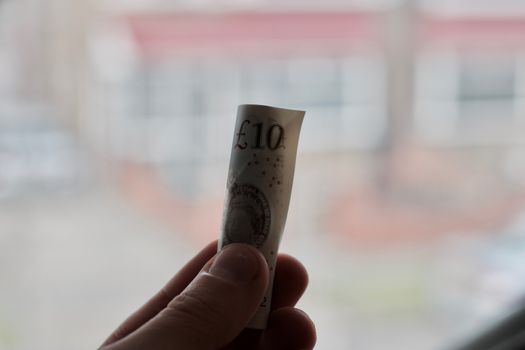British paper money in hand near white computer keyboard. Money concept.