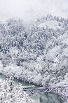 Winter landscape snow covered trees with train crossin River on Bridge