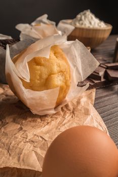 Homemade muffins with chocolate and baking ingredients.