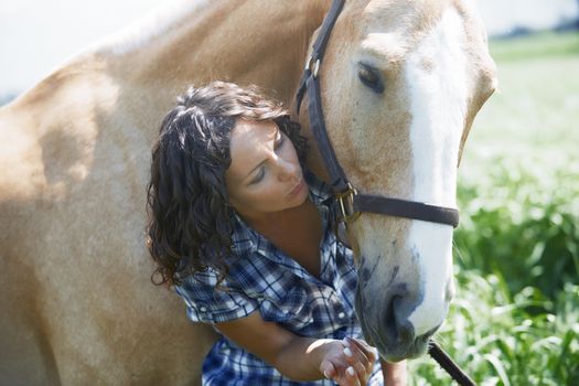 Woman and horse together at paddock