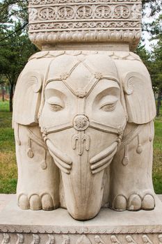 An elephant carved into the bottom of a stone pillar.