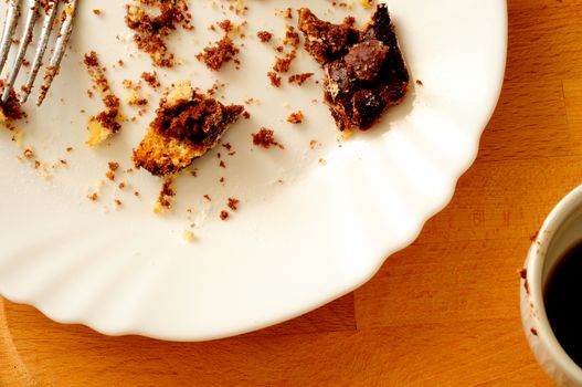 top view of leftover chocolate cake, with dirty chocolate coffee cup 