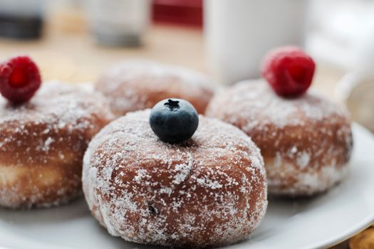 Delicious doughnuts on the white plate. Sweet fresh food concept.