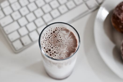 Fresh and delicious chocolate milk in glass. Office food concept.