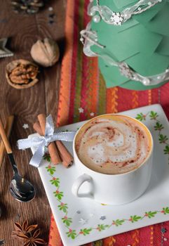 Cup of coffee and Christmas decorations on wooden table