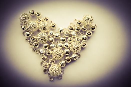 selection of different silver beads shaped into a heart