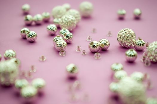 selection of scattered silver beads on pink background