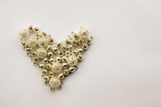 selection of different silver beads shaped into a heart