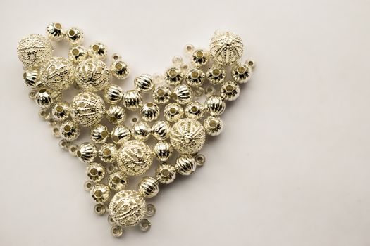 selection of different silver beads shaped into a heart