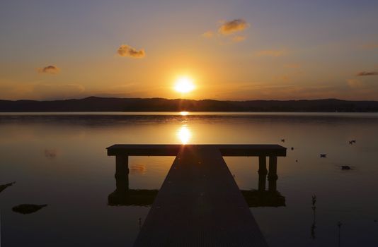 Sunset over the jetty with reflection in waters