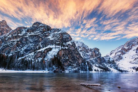 winter sunrise with colorful cloudscape over Lago di Braies, Dolomites, Italy