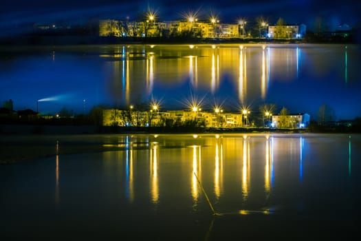 night landscape of a city reflection in the water photo with a shutter speed of Siberia winter