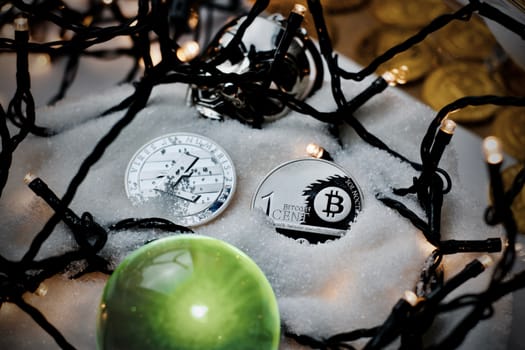 Digital currency physical metal bitcoin coin. Crypto currency christmas snow composition.