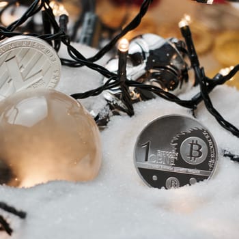 Digital currency physical metal bitcoin coin. Crypto currency christmas snow composition.