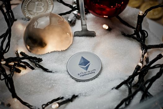 Digital currency physical grey ethereum token. Christmas snow concept.