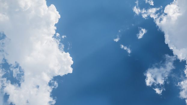 White fluffy clouds on a blue sky background