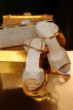 Couple of gold shoes on a gold background close-up