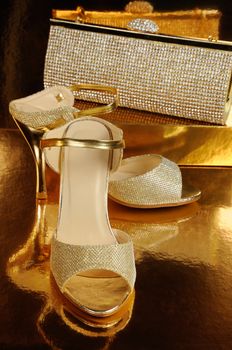 Couple of gold shoes on a gold background close-up