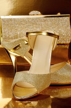 Couple of gold shoes on a gold background close-up